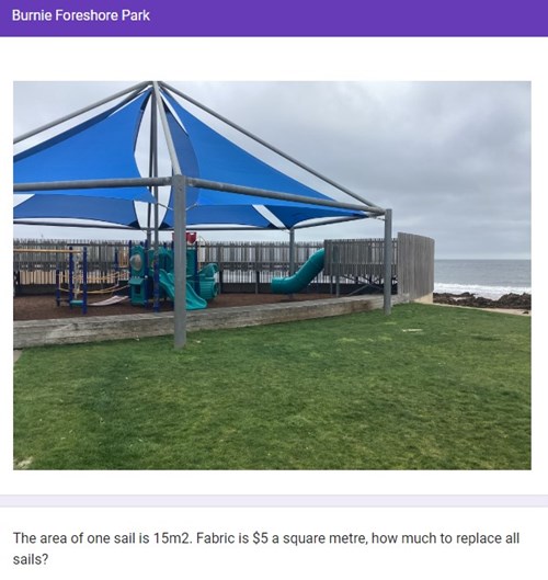 A playground with blue triangle shaped shade sails over equipment